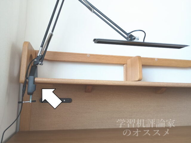 デスクライトのクランプ金具を上棚の棚板の手前側に取り付けた状態